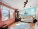 Inviting living room with wood floors, light blue accent wall, and comfortable white sofa at 907 Rose Ln, The Villages, FL 32159