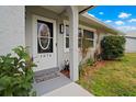 Inviting front entrance with decorative glass door, manicured bushes, and a welcome mat at 1074 Abeline Dr, Deltona, FL 32725