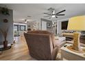 Comfortable living room features a large ceiling fan, wood flooring, and neutral decor at 1074 Abeline Dr, Deltona, FL 32725