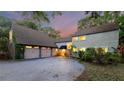 Charming two-story home featuring an attached two-car garage, lush landscaping, and a well-maintained driveway at 120 Beach St, Ponce Inlet, FL 32127