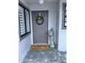Welcoming front entrance features a gray door with a wreath and a 'Welcome' doormat at 168 Olive Tree Cir # 168, Altamonte Springs, FL 32714