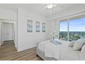 Bright bedroom featuring balcony access with city views, hardwood flooring, and ceiling fan at 1900 N Atlantic Ave # 901, Daytona Beach, FL 32118