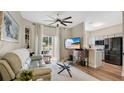 Bright living room with modern fan, plush sofa, view of the lanai and open to the kitchen at 221 Aston Grande Dr, Daytona Beach, FL 32124