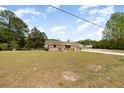 A charming single-story house with a large front yard and mature trees, creating a serene and inviting outdoor space at 2485 Se 159Th Lane Rd, Summerfield, FL 34491