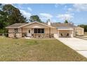Inviting single-story home with stone accents, a covered carport, and a well-maintained yard, offering a cozy curb appeal at 2485 Se 159Th Lane Rd, Summerfield, FL 34491
