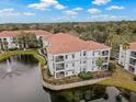 Aerial view of condo complex surrounded by lush landscaping and a tranquil pond with a fountain at 2639 Maitland Crossing Way # 103, Orlando, FL 32810