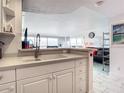 Bright kitchen area with white cabinets, and stainless steel faucet, adjacent to the living space at 2700 N Atlantic Ave # 801, Daytona Beach, FL 32118