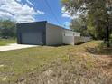 Modern home with a two-car garage and partial fencing in a serene, natural setting at 28 Guava Ln, Ocklawaha, FL 32179