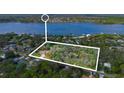 Aerial view showing a property line for a residential property with a large lake nearby and surrounded by woods at 2910 Hardy Ave, New Smyrna Beach, FL 32168