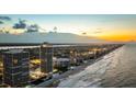 Picturesque aerial view of beachfront condos along the coastline, capturing ocean and city lights at 3000 N Atlantic Ave # 24, Daytona Beach, FL 32118