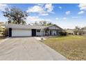 Single-story home showcasing a front lawn and a long driveway to the garage at 480 Columbus Ave, Orange City, FL 32763