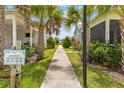 Picturesque sidewalk lined with lush landscaping, palm trees, and charming homes in a vibrant community at 562 Landshark Blvd, Daytona Beach, FL 32124