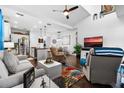 Bright open-concept living room with hardwood floors, modern furnishings, and seamless flow into the kitchen at 562 Landshark Blvd, Daytona Beach, FL 32124