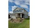 Two-story home with gray siding, blue shutters, and a well manicured front lawn at 7024 Lanier Falls Rd, Deland, FL 32724