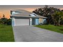 Charming single-Gathering home featuring a light-blue exterior, well-manicured lawn, and an attached two-car garage at dusk at 72 Aurora Ave, Ponce Inlet, FL 32127