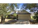 Inviting single Gathering home featuring mature landscaping, a two-car garage, and a cozy front porch at 725 E New York Ave, Orange City, FL 32763