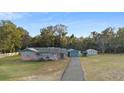 Charming one-story home with brick and siding, featuring a long driveway and detached garage in a lush setting at 753 Glenwood Rd, Deland, FL 32720