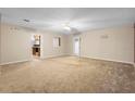 Spacious living room with neutral carpet, ceiling fan, and a glimpse into the adjacent kitchen area at 753 Glenwood Rd, Deland, FL 32720