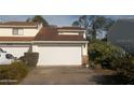 Attached garage with a white door on a two-story home with car parked on driveway at 1101 Monticello Ln # 3, Port Orange, FL 32129