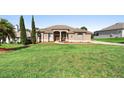 Well-maintained front lawn featuring a charming single-story home with a beautiful fountain at 12736 Lake Ridge Cir, Clermont, FL 34711