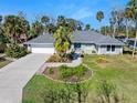Charming single-story home with a well-manicured lawn and a beautiful garden in front at 13 Sandcastle Dr, Ormond Beach, FL 32176