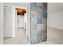 Bright hallway featuring tiled floors, slate accent wall and access to kitchen at 140 Orchid Woods Ct # 7A, Deltona, FL 32725