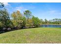 Scenic backyard overlooking a tranquil lake surrounded by lush greenery and mature trees at 160 Limewood Pl # 1, Ormond Beach, FL 32174