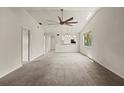 Bright, carpeted living room featuring a ceiling fan, and views into the kitchen at 160 Limewood Pl # 1, Ormond Beach, FL 32174