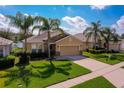 Inviting single-Gathering home with mature palm trees, green lawn, and partial lake view at 1750 Savannah Ln, Port Orange, FL 32128