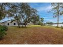 Spacious backyard featuring mature trees, direct water access, and screened in lanai at 1983 Stacey Cir, Deltona, FL 32738