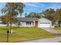 Charming home featuring a well-manicured lawn, attached garage, and freshly painted exterior at 1983 Stacey Cir, Deltona, FL 32738