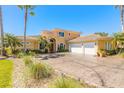Beautiful tan home with a stamped concrete driveway, mature palms and manicured landscaping at 20 Promenade At Lionspaw, Daytona Beach, FL 32124