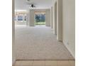 Spacious living room with neutral carpet, leading to sliding glass doors and archways at 212 Stonington Way, Deland, FL 32724