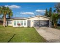 Charming single-story home with a well-maintained lawn, mature landscaping, and an attached two-car garage at 2211 Green St, South Daytona, FL 32119