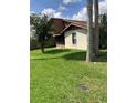 Spacious backyard features lush green lawn, mature trees, and screened in porch at 301 Paradise Ln, Edgewater, FL 32132