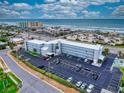Aerial view of a condo building across the street from the beach, with a parking lot, and easy access to the ocean at 3700 S Atlantic Ave # 111, New Smyrna Beach, FL 32169