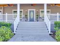 Inviting front porch with rocking chairs and a charming blue door at 5306 Empire Church Rd, Groveland, FL 34736
