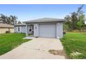 Cozy home with a gray exterior, a two-car garage, and a well-kept lawn providing curb appeal at 599 S Cedar Ave, Orange City, FL 32763