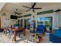 Covered patio with ceiling fans, a dining table, and a view of the lake at 6071 Sabal Hammock Cir, Port Orange, FL 32128
