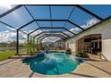 Relaxing screened-in pool and spa with an outdoor dining area and lake views at 6071 Sabal Hammock Cir, Port Orange, FL 32128