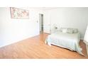 Clean bedroom with light wood floors, white walls and ceilings, a bed, and view into another room at 6152 Sequoia Dr, Port Orange, FL 32127