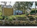 Landscaped entrance to Riverwood Plantation features a stone wall and sign, welcoming residents and visitors alike at 6152 Sequoia Dr, Port Orange, FL 32127