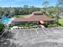 Community clubhouse featuring a pool, mature trees, and ample parking at 6157 Sequoia Dr, Port Orange, FL 32127