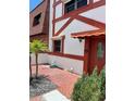 Charming two-story townhome featuring a white and red Tudor-style facade with well-maintained landscaping and a paver entry at 625 N Halifax Ave # 15, Daytona Beach, FL 32118