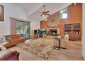 Spacious living room featuring a brick fireplace, wood paneling, and vaulted ceilings at 749 E Wisconsin Ave, Orange City, FL 32763