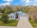 Beautiful one-story home with a light blue facade, two car garage, and well maintained lawn at 971 Cascades Park Trl, Deland, FL 32720