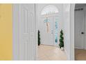 Bright foyer with white tiled floors, decorative plants, and a large front door with side windows at 971 Cascades Park Trl, Deland, FL 32720