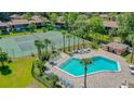 Community pool and tennis courts surrounded by lush landscaping offers a luxurious experience at 100 Sweetgum Woods Ct # 11D, Deltona, FL 32725