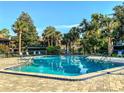 Relaxing swimming pool surrounded by mature trees and lounge chairs on a sunny day at 100 Sweetgum Woods Ct # 11D, Deltona, FL 32725