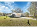 Spacious lawn and the side view of a single-story home with a light-yellow painted exterior at 141 N Mcdonald Ave, Deland, FL 32724